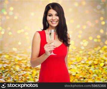 people, holidays, christmas and celebration concept - beautiful sexy woman in red dress with champagne glass over golden glitter or lights background
