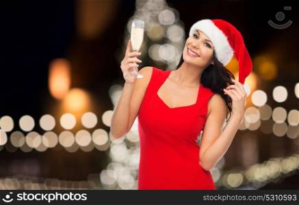 people, holidays, christmas and celebration concept - beautiful sexy woman in santa hat and red dress with champagne glass. beautiful sexy woman in santa hat and red dress