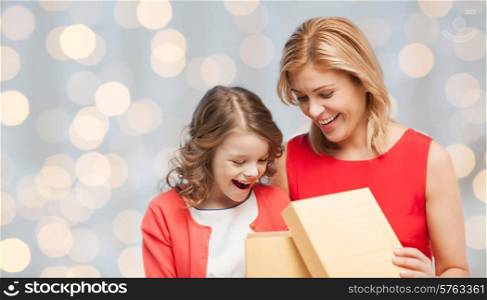 people, holidays, christmas and family concept - happy mother and daughter opening gift box over holiday lights background