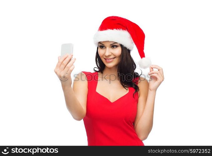 people, holidays, christmas and technology concept - beautiful sexy woman in red santa hat taking selfie picture by smartphone