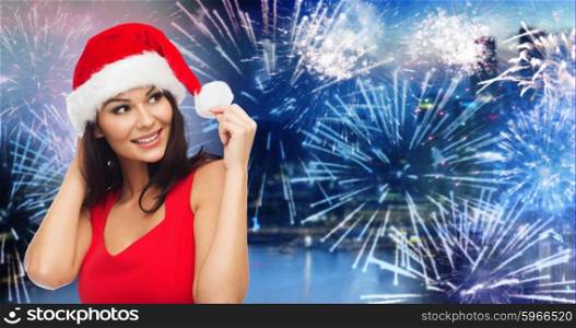 people, holidays, christmas, new year party and celebration concept - beautiful sexy woman in santa hat and red dress over night city and firework background