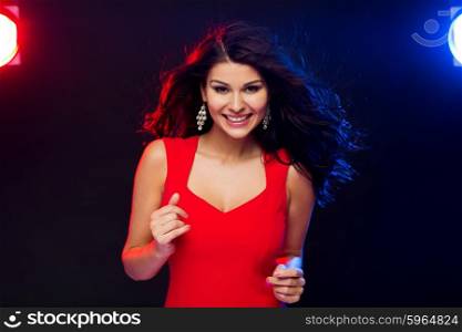 people, holidays, disco, night lifestyle and leisure concept - beautiful sexy woman in red dress dancing at nightclub