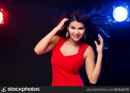 people, holidays, disco, night lifestyle and leisure concept - beautiful sexy woman in red dress dancing at nightclub