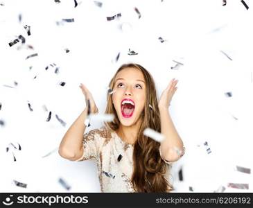 people, holidays, emotion and glamour concept - happy young woman or teen girl in fancy dress with sequins and confetti at party