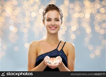 people, holidays, jewelry and luxury concept - smiling woman in evening dress and diamond earrings over lights background