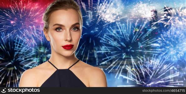 people, holidays, luxury and fashion concept - beautiful woman in black with red lips over night city firework background