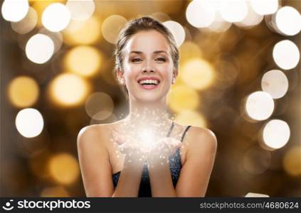 people, holidays, magic and luxury concept - happy woman dress with fairy dust on palms