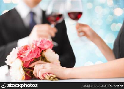people, holidays, marriage and celebration concept - happy engaged couple with flower clinking wine glasses over blue lights background