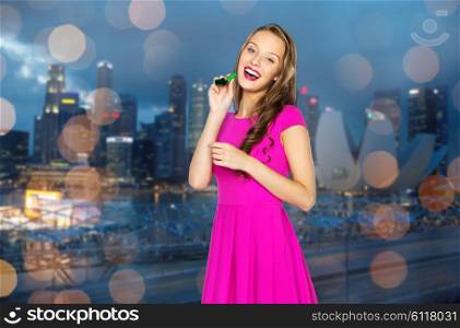 people, holidays, night life and celebration concept - happy young woman or teen girl in pink dress and party cap
