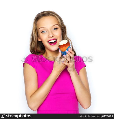 people, holidays, party, junk food and celebration concept - happy young woman or teen girl in pink dress with birthday cupcake