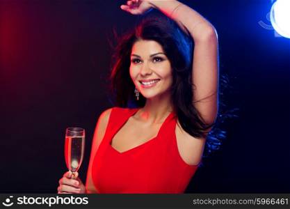 people, holidays, party, night lifestyle and leisure concept - beautiful sexy woman in red dress with champagne glass dancing at nightclub