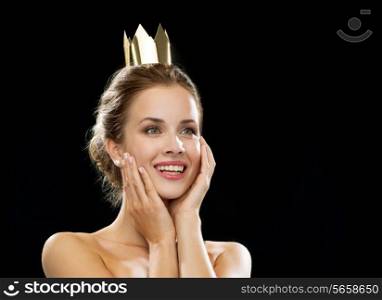people, holidays, royalty and glamour concept - laughing woman wearing golden crown over black background