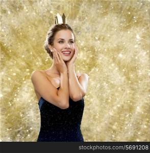 people, holidays, royalty and glamour concept - smiling woman in evening dress wearing golden crown over yellow lights background