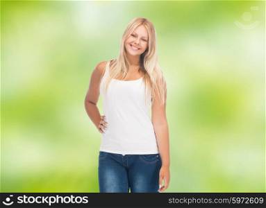 people, holidays, style and body type concept - smiling young woman in blank white shirt and jeans over green natural background