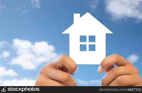 people, home, real estate and mortgage concept - close up of hands holding paper house