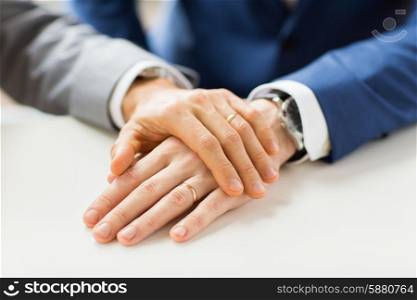 people, homosexuality, same-sex marriage and love concept - close up of happy male gay couple hands with wedding rings on