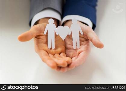 people, homosexuality, same-sex marriage and love concept - close up of happy male gay couple holding paper cutout love symbol