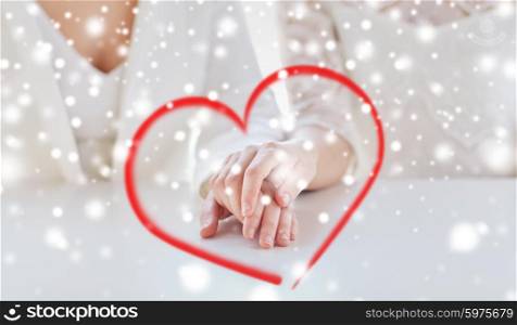 people, homosexuality, same-sex marriage and love concept - close up of happy married lesbian couple hands over snow effect