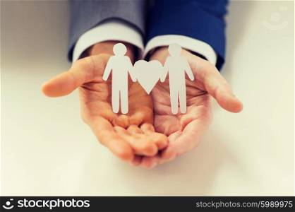people, homosexuality, same-sex marriage and love concept - close up of happy male gay couple holding paper cutout love symbol