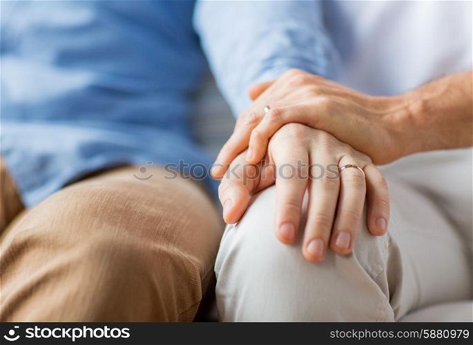 people, homosexuality, same-sex marriage, gay and love concept - close up of happy male gay couple holding hands with wedding rings on