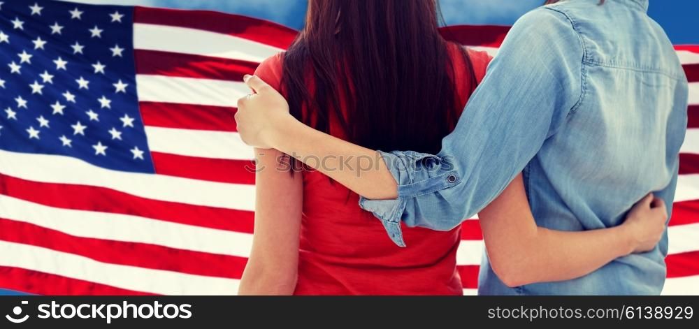 people, homosexuality, same-sex marriage, gay and love concept - close up of happy women couple hugging over american flag background