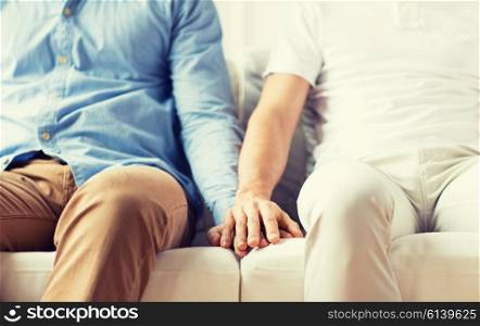 people, homosexuality, same-sex marriage, gay and love concept - close up of happy male gay couple holding hands