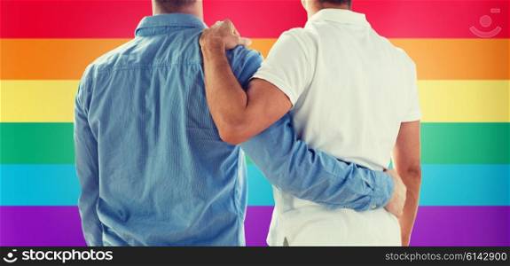 people, homosexuality, same-sex marriage, gay and love concept - close up of happy male gay couple or friends hugging from back over rainbow flag background