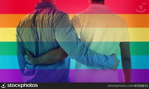 people, homosexuality, same-sex marriage, gay and love concept - close up of happy male gay couple hugging from back over rainbow flag stripes background