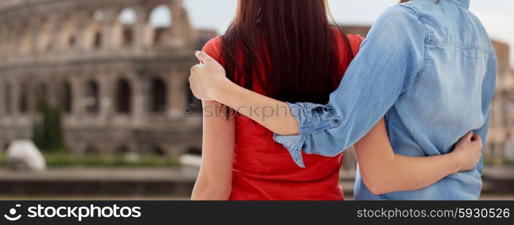 people, homosexuality, same-sex marriage, travel and gay love concept - close up of happy lesbian couple hugging over coliseum in rome background