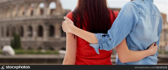 people, homosexuality, same-sex marriage, travel and gay love concept - close up of happy lesbian couple hugging over coliseum in rome background