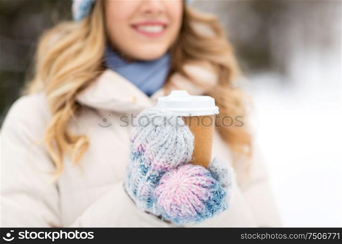 people, hot drinks and leisure concept - close up of happy woman drinking takeaway coffee outdoors in winter. happy woman drinking coffee outdoors in winter