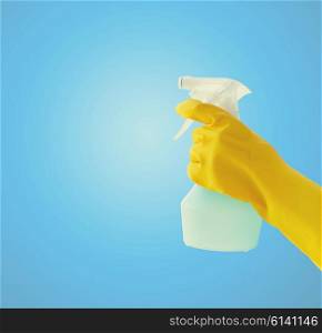 people, housework, advertisement and housekeeping concept - close up of hand with cleanser spraying over blue background