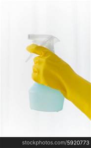 people, housework and housekeeping concept - close up of hand with cleanser spraying home