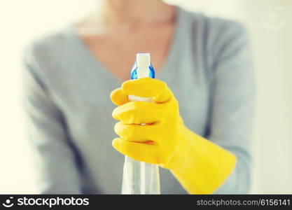 people, housework and housekeeping concept - close up of happy woman with cleanser spraying home