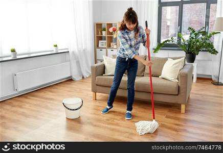 people, housework and housekeeping concept - happy asian woman or housewife with mop cleaning floor at home. woman or housewife with mop cleaning floor at home