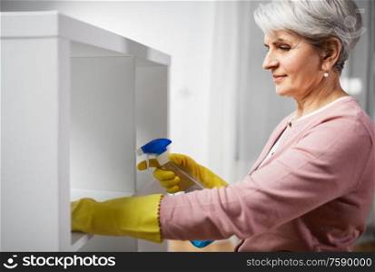 people, housework and housekeeping concept - happy senior woman cleaning rack with detergent at home. senior woman cleaning rack with detergent at home