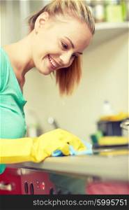 people, housework and housekeeping concept - happy woman cleaning cooker at home kitchen