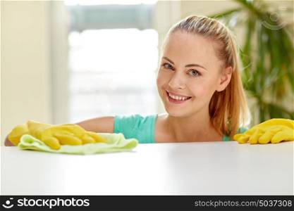 people, housework and housekeeping concept - happy woman cleaning table at home. happy woman cleaning table at home