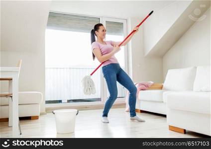 people, housework and housekeeping concept - happy woman or housewife with mop cleaning floor and having fun at home. woman or housewife with mop cleaning floor at home. woman or housewife with mop cleaning floor at home