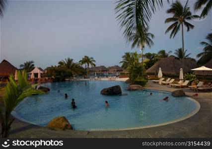 People in a swimming pool at a seaside resort, Moorea, Tahiti, French Polynesia, South Pacific