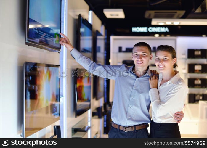 people in consumer electronics retail store looking at latest laptop, television and photo camera to buy