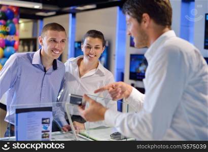 people in consumer electronics retail store looking at latest laptop, television and photo camera to buy