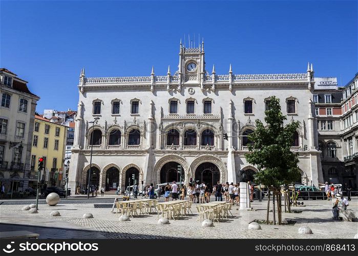 People in front of the Neo-Manueline style facade of Rossio railway station in the central historic area of Lisbon, Portugal