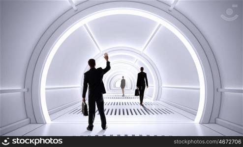 People in futuristic interior. Mixed media. Businesspeople walking in futuristic designed 3D room