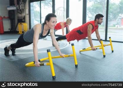 people in gym class leaning on apparatus in plank position