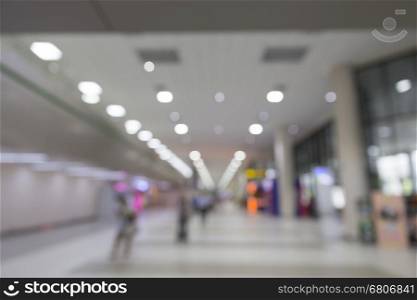 people in interior airport terminal building, blur background