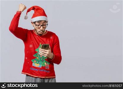 People in santa hat looking at cell phone excited, Excited young man in christmas hat using cellphone celebrating, Excited guy in christmas hat looking at cellphone and celebrating