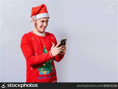 People in santa hat using and smiling at cellphone isolated, Smiling young man in christmas hat using cellphone isolated. Happy guy in christmas hat smiling at cellphone isolated