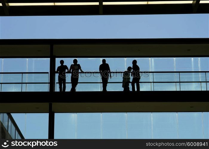 people in silhouette at a modern building