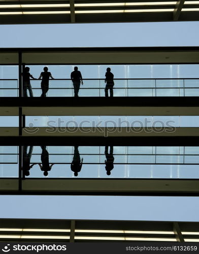 people in silhouette at a modern building